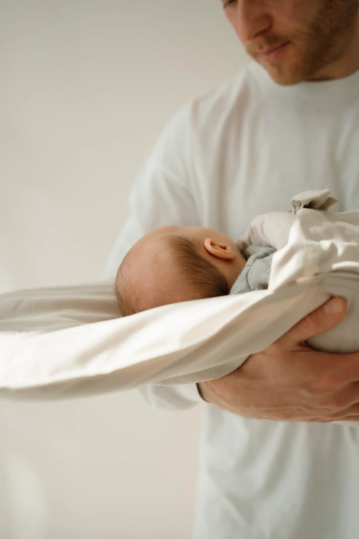 Baby schläft im CosyMe auf dem Arm eines Mannes