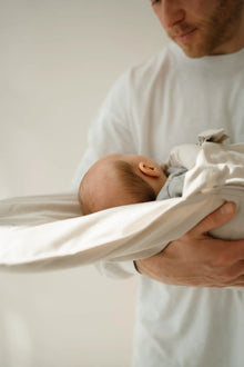 Baby schläft im CosyMe auf dem Arm eines Mannes