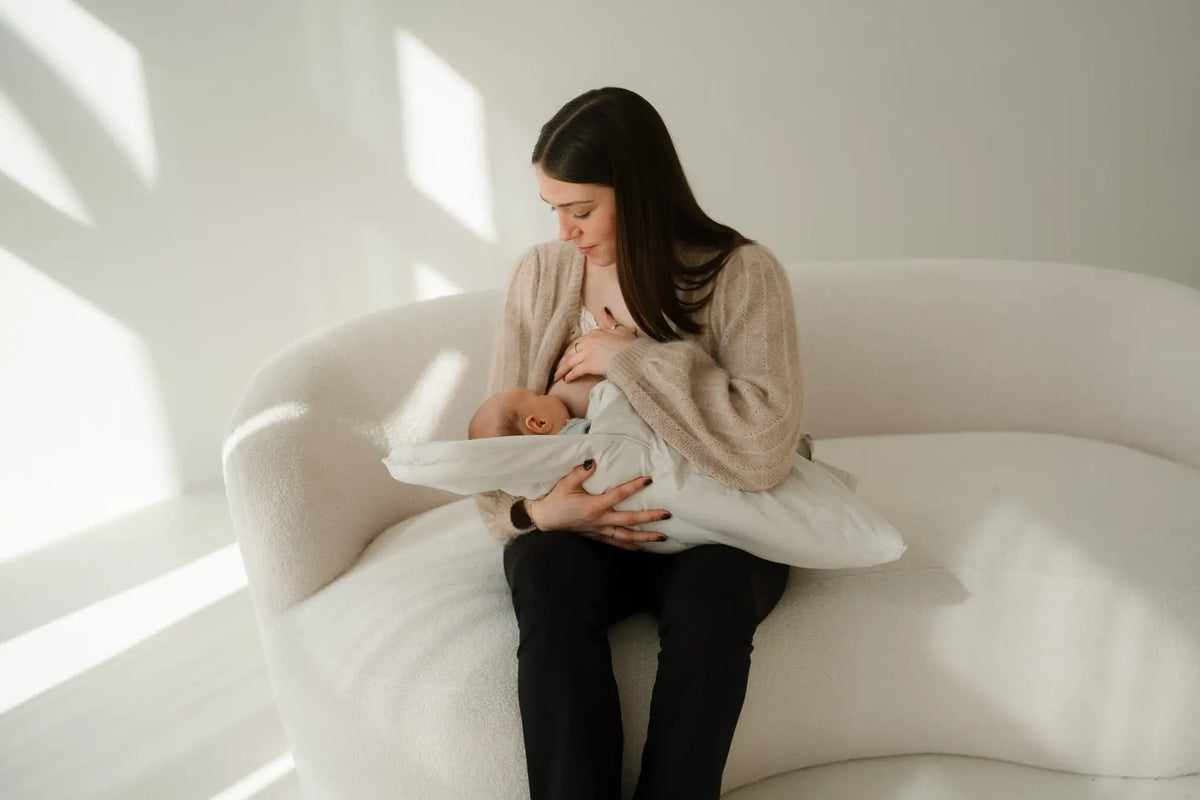 Baby schläft im CosyMe auf dem Arm seiner Mutter