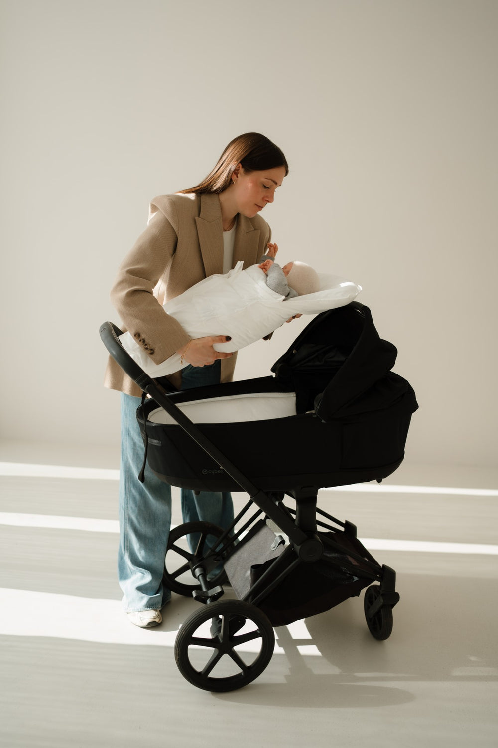 Baby liegt im CosyMe und wird in einen Kinderwagen gelegt