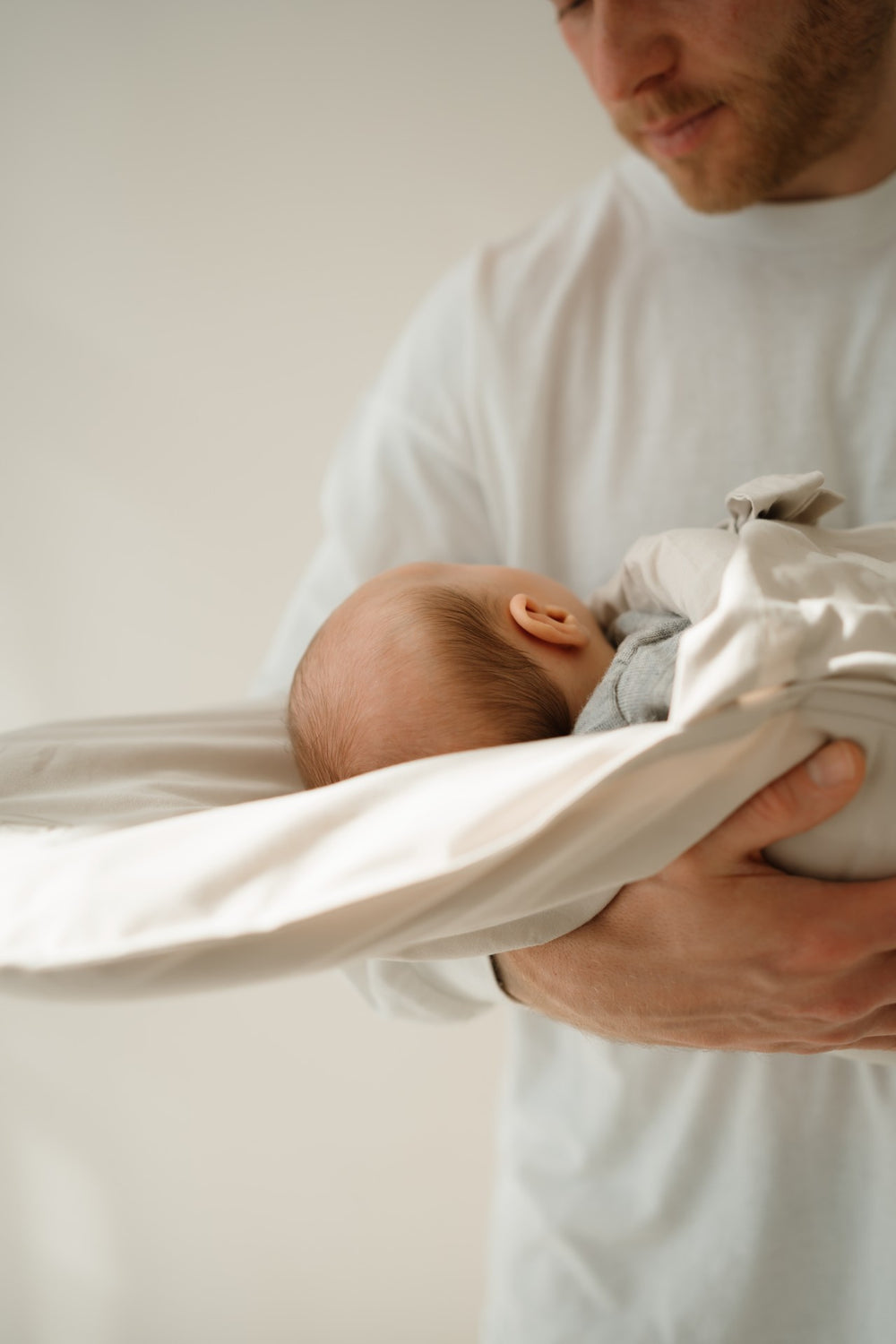 Baby schläft im CosyMe auf dem Arm eines Mannes